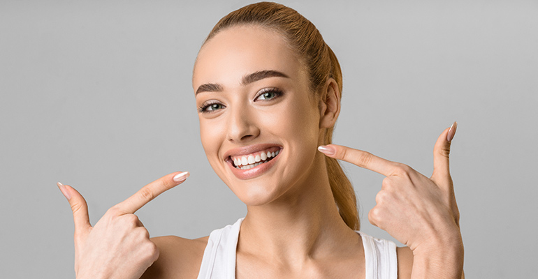 Una paciente se muestra satisfecha por haber conseguido corregir su sonrisa gingival con la ayuda del ácido hialurónico.